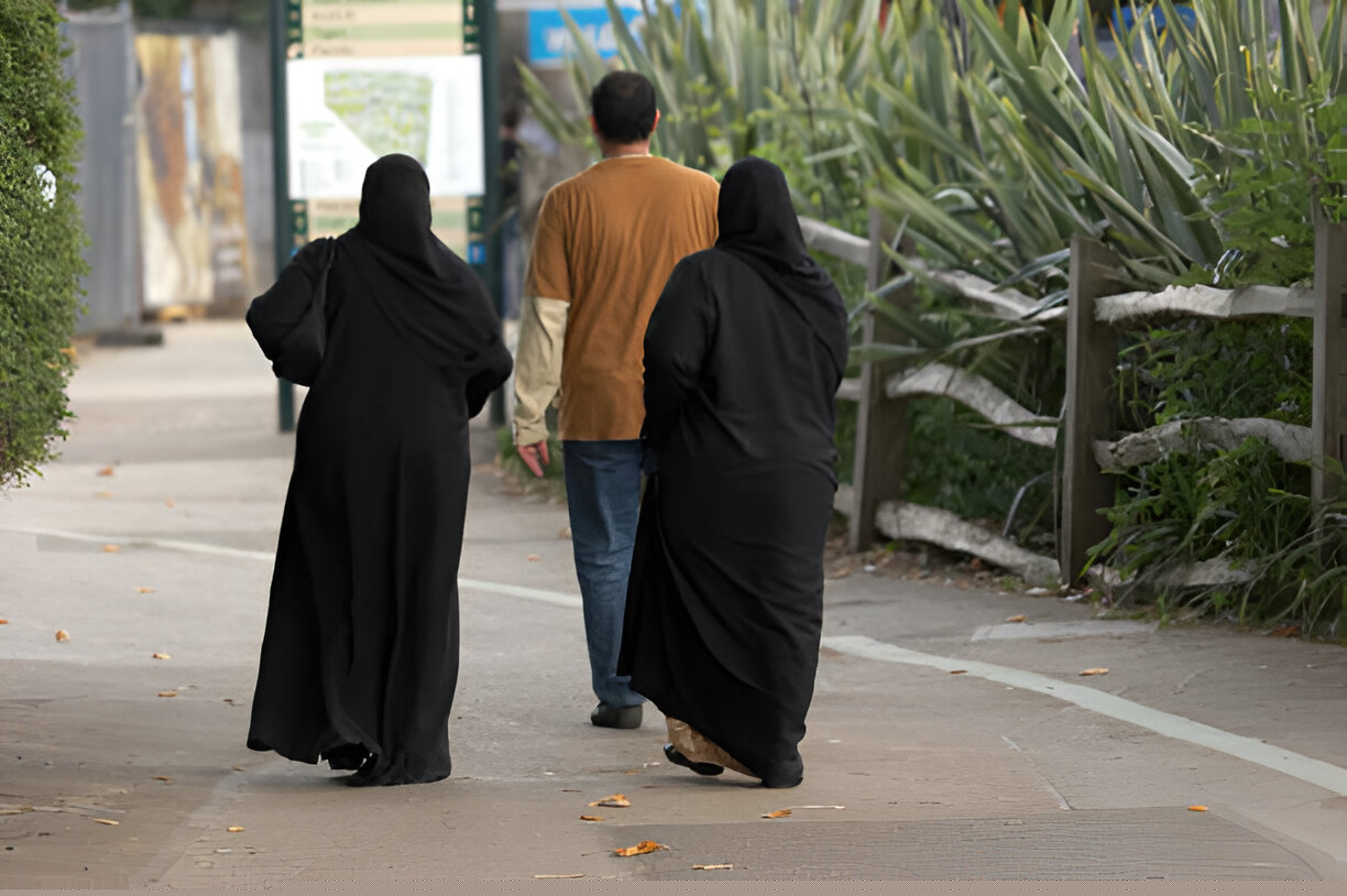 Proper clothing for Arbaeen pilgrimage from Najaf to Karbala showing men in thobes and women in abayas