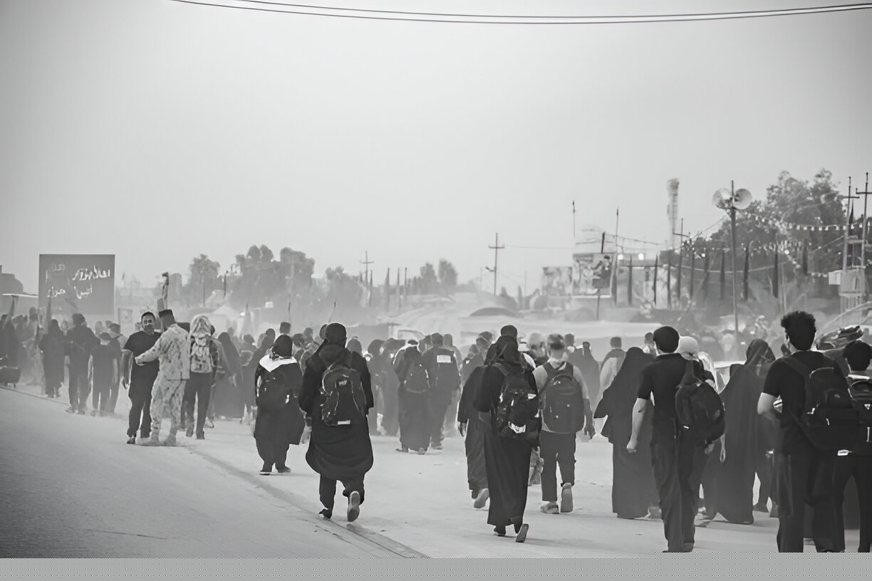 Group of first-time pilgrims walking the 80km Arbaeen route from Najaf to Karbala with backpacks and flags